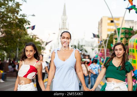 Touristen machen einen Spaziergang entlang des Cali River Boulevard mit der Kirche La Ermita im Hintergrund in der Stadt Cali in Kolumbien Stockfoto