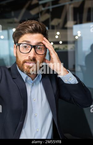 Vertikale Aufnahme, Videoanrufe Geschäftsführer, der per Fernzugriff über die Smartphone-App spricht und auf die Kamera schaut Unglückliches Gespräch und Arbeiten mit Kollegen und Partnern wütender Chef. Stockfoto