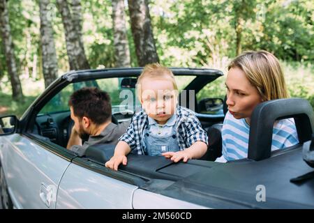 Mama, Papa und kleiner Sohn in einem Cabriolet. Sommer Familienausflug in die Natur Stockfoto