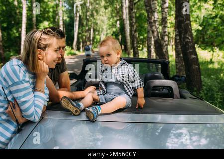 Mama, Papa und kleiner Sohn in einem Cabriolet. Sommer Familienausflug in die Natur Stockfoto