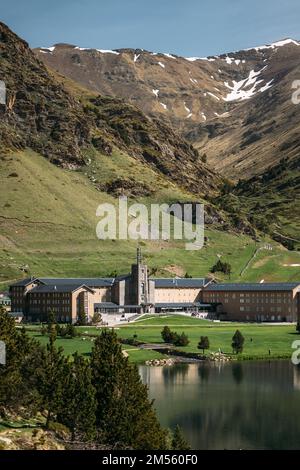 Das wunderschöne Tal von Vall de Nuria ist ein malerischer, atemberaubender Ort in Spanien. Der Tempel der Nuria am Ufer des Sees am Fuße des Berges ist überflutet mit Stockfoto