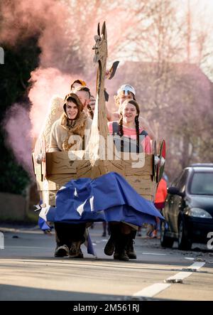 East Hoathly, Großbritannien. 26. Dezember 2022. Pram-Rennen am zweiten Weihnachtsfeiertag: Teams in einem schicken Kostümrennen durch das Dorf East Hoathly in East Sussex sammeln Spenden für lokale Wohltätigkeitsorganisationen. Die jährliche Veranstaltung beginnt und endet im Kings Head Pub im Zentrum des Dorfes. Kredit: Jim Holden/Alamy Live News Stockfoto