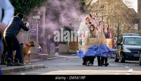 East Hoathly, Großbritannien. 26. Dezember 2022. Pram-Rennen am zweiten Weihnachtsfeiertag: Teams in einem schicken Kostümrennen durch das Dorf East Hoathly in East Sussex sammeln Spenden für lokale Wohltätigkeitsorganisationen. Die jährliche Veranstaltung beginnt und endet im Kings Head Pub im Zentrum des Dorfes. Kredit: Jim Holden/Alamy Live News Stockfoto
