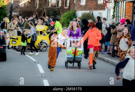 East Hoathly, Großbritannien. 26. Dezember 2022. Pram-Rennen am zweiten Weihnachtsfeiertag: Teams in einem schicken Kostümrennen durch das Dorf East Hoathly in East Sussex sammeln Spenden für lokale Wohltätigkeitsorganisationen. Die jährliche Veranstaltung beginnt und endet im Kings Head Pub im Zentrum des Dorfes. Kredit: Jim Holden/Alamy Live News Stockfoto