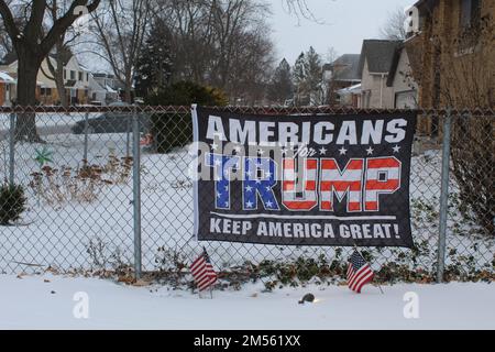 Amerikaner für Trump halten das amerikanische Banner auf einem Zaun mit Snow des Plaines, Illinois Stockfoto