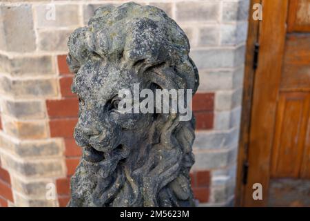 Traditionelle Zierstatue mit einem sitzenden Löwen in einem öffentlichen Park in Großbritannien. Stockfoto