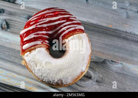 Puderzucker und Ringdonut mit Erdbeergeschmack, glasierter, hefegezogener, amerikanischer Ringdonut mit Belag, Art Foo Stockfoto