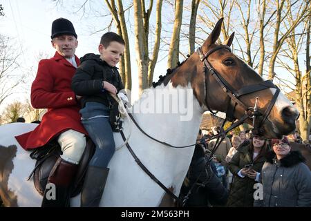 Passendes Green Essex, Großbritannien. 26. Dezember 2022. Der Jagdmeister reitet mit einem Jungen auf seinem Pferd. Hunderte von Menschen besuchen die Essex with Farmers and Union Hunt für ihre jährliche Fahrt am zweiten Weihnachtsfeiertag vom Chequers Pub im ländlichen Dorf Matching Green in Essex. Die Essex-Jagd trifft sich seit Anfang des 19. Jahrhunderts regelmäßig in Matching Green, obwohl es seit dem Jagdgesetz von 2004 nicht mehr erlaubt ist, mit Hunden Füchse zu jagen und zu töten. Kredit: MARTIN DALTON/Alamy Live News Stockfoto