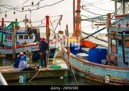 Dezember 16 2022 - Pathio Thailand Chumphon Gegend - farbenfrohe Fischerboote, die mit Flut vom Meer kommen und aufgrund des Sturms an Land gespült wurden. Stockfoto