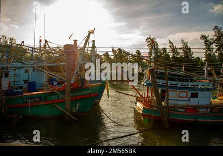 Dezember 16 2022 - Pathio Thailand Chumphon Gegend - farbenfrohe Fischerboote, die mit Flut vom Meer kommen und aufgrund des Sturms an Land gespült wurden. Stockfoto