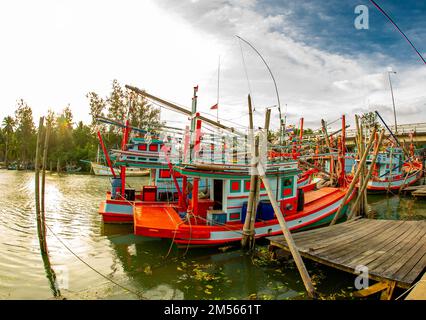 Dezember 16 2022 - Pathio Thailand Chumphon Gegend - farbenfrohe Fischerboote, die mit Flut vom Meer kommen und aufgrund des Sturms an Land gespült wurden. Stockfoto