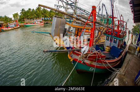 Dezember 16 2022 - Pathio Thailand Chumphon Gegend - farbenfrohe Fischerboote, die mit Flut vom Meer kommen und aufgrund des Sturms an Land gespült wurden. Stockfoto