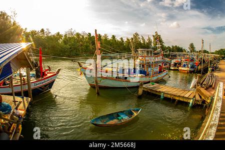 Dezember 16 2022 - Pathio Thailand Chumphon Gegend - farbenfrohe Fischerboote, die mit Flut vom Meer kommen und aufgrund des Sturms an Land gespült wurden. Stockfoto