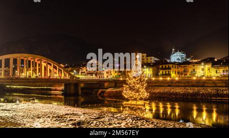 San Michele all'Adige in der Provinz Trient: Der große Weihnachtsbaum am Fluss Adige, Nachtfotografie - Trentino Alto Adige - Italien - Europa Stockfoto