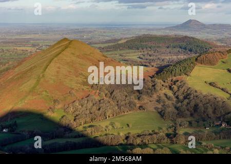 Der Lawley, Hügel in Shropshire, England, mit dem Wrekin, ein weiterer Hügel im Hintergrund. Der Schatten von Caer Caradoc im Vorfeld. Stockfoto