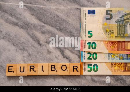 Word EURIBOR ist in Holzbuchstaben geschrieben, nahe an einem Teil der Euro-Banknoten 5, 10, 20 und 50. Stockfoto