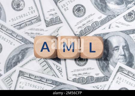 AML-Wort zu Holzblöcken und US-Dollar-Scheinen. Konzept zur Bekämpfung von Geldwäsche Stockfoto