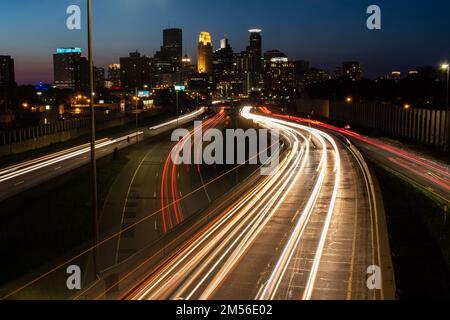 Eine Zeitraffer der Straßenlaternen in Minneapolis, Minnesota, bei Nacht mit einer Stadtlandschaft im Hintergrund Stockfoto