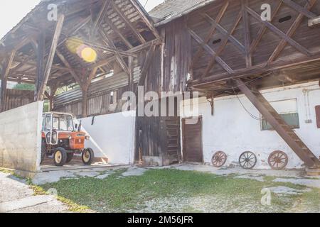 Alte Scheune mit Traktor in einem Alpendorf in Slowenien Stockfoto