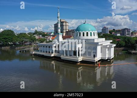 Drohnenfoto der weißen Moschee mit grüner Kuppel am Ufer des Flusses in Kuching, Sarawak, Malaysia Stockfoto