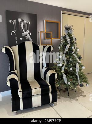 Marco Pierre Whites Stuhl in seinem Restaurant in Milton Keynes, mit einem Weihnachtsbaum. Es ist ein Mr. McQueen-Flügelsessel, hergestellt von Richard James. Stockfoto