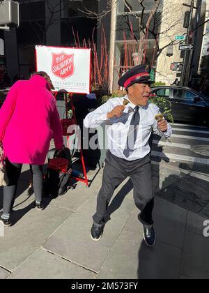 Der Glockenläger der Heilsarmee singt für Spenden entlang der 5. Avenue am Black Friday in Manhattan, New York City. Stockfoto