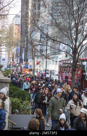 Auf der 42. Street schlendern Menschenmassen in östlicher Richtung an der New York Public Librry vorbei, eine Woche vor Weihnachten während der Weihnachtszeit. Stockfoto