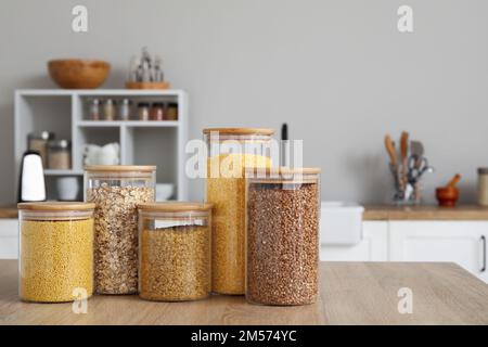 Glasgefäße mit verschiedenen Cerealien auf einem Holztisch in der Küche Stockfoto