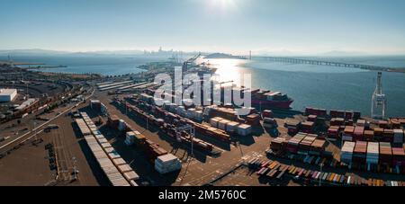 Oakland Outer Harbor aus der Vogelperspektive. Beladene Lkw, die sich mit Containerkranen bewegen. Stockfoto