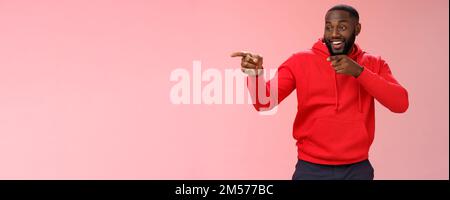 Hey, Mann, was ist. Portrait frech selbstbewusst ausgehende afroamerikanische bärtige Mann in Club sehen Freunde machen hallo Geste zeigen linken Finger Stockfoto