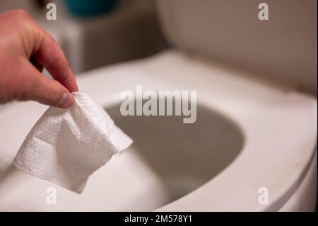 Einweg-Wischtücher werden auf der Toilette heruntergespült, wo sie Verstopfung und Probleme mit der Abwasserbehandlung verursachen können. Stockfoto