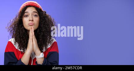 Nahaufnahme von niedlichen weiblichen Freundin Betteln bringen ihre Lieblings-Süßigkeiten halten Hände in beten Falten Lippen und starrte mit Engel unschuldigen Blick auf Stockfoto