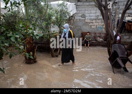 Gaza, Palästina. 26. Dezember 2022. Eine palästinensische Frau betritt ihr Haus, nachdem es in Khan Yunis, im südlichen Gazastreifen, von Regen überflutet wurde. Credit: SOPA Images Limited/Alamy Live News Stockfoto