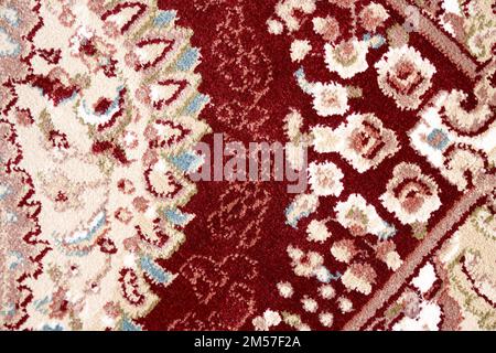 Fragment aus persischer Teppichstruktur, Makrofoto für Hintergrund. Nahaufnahme von Details komplexer Muster mit Blumenverzierung des Flurteppichs. Texturkonzept und Hintergrund. Stockfoto