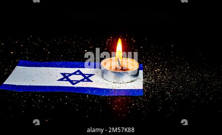 Israelische Flagge und brennende Kerzen darüber, Holocaust-Gedenktag Stockfoto