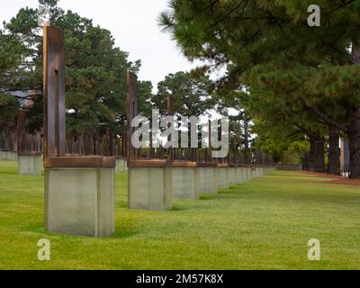 Blick aus dem niedrigen Winkel auf eine Reihe leerer Bronze- und Glasstühle im Feld der leeren Stühle Memorial für die 168 Erwachsenen und Kinder, die in Oklahoma getötet wurden Stockfoto