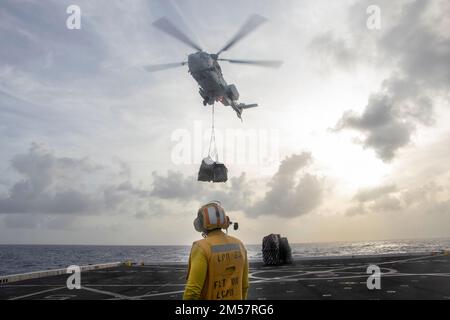 PACIFIC OCEAN (4. Dezember 2022) – ein MH-60s Sea Hawk Helikopter vom Trockenfrachtschiff USNS Charles Drew (T-AKE 10) liefert Fracht an die Amphibienladestelle USS Anchorage (LPD 23) während einer vertikalen Wiederauffüllung (VERTREP) am 4. Dezember 2022. Ein VERTREP versorgt Marineschiffe effizient, ohne dass sie in den Hafen ziehen müssen. Die Makin Island Amphibious Ready Group, bestehend aus dem amphibischen Sturmschiff USS Makin Island (LHD 8) und den amphibischen Transportdocks USS Anchorage (LPD 23) und USS John P. Murtha (LPD 26), ist im US-7.-Flottengebiet mit der einschifften 13. Marine Ex tätig Stockfoto