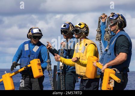 221225-N-SN516-1112 PHILIPPINE SEA (25. DEZEMBER 2022) USA Navy-Matrosen zeigen der Hubschrauber-Crew während der Quartiere an Bord der Arleigh-Burke-Klasse-Zerstörerin USS Decatur (DDG 73), wie Ketten und Keile entfernt werden. Decatur, Teil der Nimitz Carrier Strike Group, ist derzeit in der 7.-Flotte im Einsatz und führt Routinevorgänge durch. 7. Fleet sind die USA Die größte Flotte der Navy, die mit einer Anzahl von Flotten ausgestattet ist, interagiert regelmäßig mit 35 Seenationen, um eine freie und offene Region im Indo-Pazifik zu erhalten. (USA Marinefoto von Mass Communication Specialist 2. Class David Ne Stockfoto