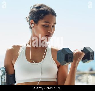 Du bist stärker, als du denkst. Eine junge Frau, die beim Training Kurzhanteln benutzt. Stockfoto