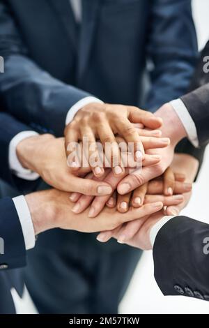 Gemeinsam können wir alles erreichen. Nahaufnahme einer Gruppe von Geschäftsleuten, die in einem Zusammentreffen stehen, mit gestapelten Händen. Stockfoto