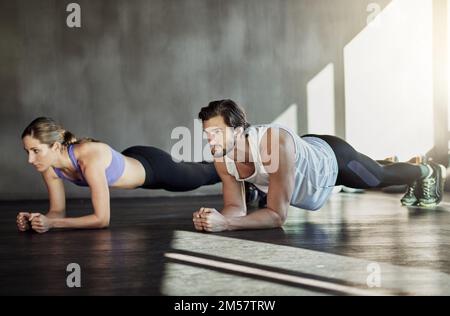 Sie können diese Pose für immer halten. Zwei junge Leute, die sich im Rahmen ihres Trainings zusammentun. Stockfoto