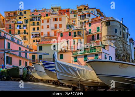 Blick auf die traditionellen Fischerboote und farbenfrohen Terrakotta-Häuser in der Altstadt von Manarola in Cinque Terre, Italien Stockfoto