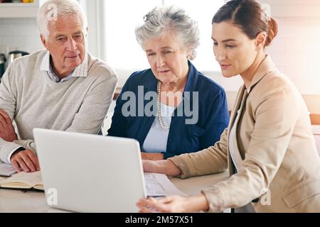 Ihnen dabei helfen, ihre finanziellen Träume zu verwirklichen. Ein älteres Paar, das Rat von seinem Finanzberater bekommt. Stockfoto
