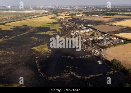 Ein Dateifoto vom 20.7/2022, das nach einem Brand im Dorf Wennington, East London, nach Temperaturen von über 40C Grad in Großbritannien zum ersten Mal überhaupt stattfand. Die 10 teuersten Stürme, Überschwemmungen und Dürren im Jahr 2022 kosteten in einem „verheerenden“ Jahr an vorderster Front des Klimawandels mindestens drei Milliarden US-Dollar (32,5 Milliarden US-Dollar), so ein Bericht. Die christliche Hilfe hat die schlimmsten klimabedingten Katastrophen des Jahres aufgezeigt, da die Welt von heftigeren Stürmen, heftigen Regenfällen und Dürren getrieben wird, die durch steigende globale Temperaturen infolge menschlicher Aktivitäten ausgelöst werden. Ausgabedatum: Dienstag, 27. Dezember Stockfoto