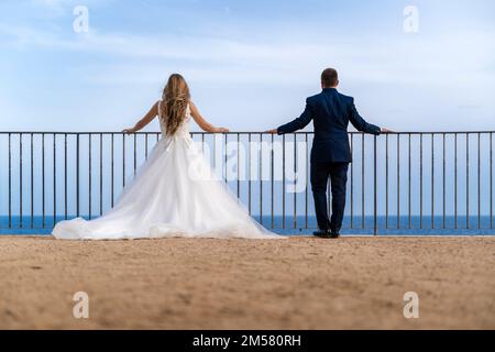 Porträt eines frisch verheirateten Paares mit dem Meer und dem Himmel im Hintergrund Stockfoto