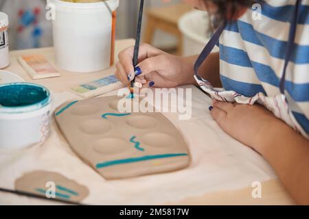 Frau malt und dekoriert eine Keramik-Werkstatt. Handwerk, Kunst und Hobbys. Stockfoto