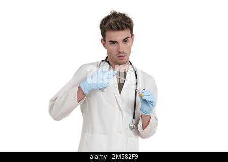 Junger kaukasischer Arzt, der isoliert eine Dosis eines Impfstoffs vorbereitet. Stockfoto