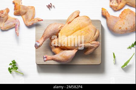 Ganzes Huhn auf einer flachen Küchenzeile mit Hühnerstücken von oben Stockfoto