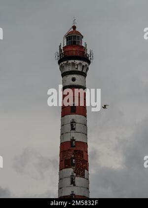 Hoher Leuchtturm bei bewölktem Wetter. Weiß-roter Leuchtturm. Osinovets Leuchtturm, Lake Ladoga Stockfoto