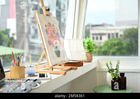 Einrichtung im Art Studio mit Leinwand, Pinseln, Farbtupfer auf weißem Tresen. Malerraum mit Werkzeugen und Zubehör Stockfoto